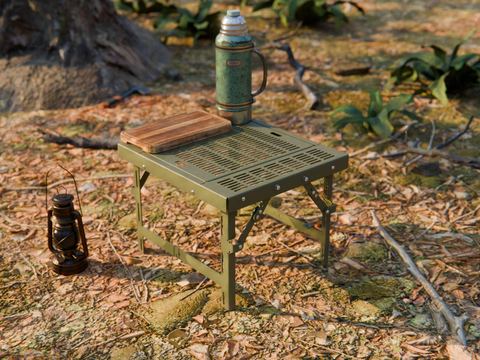 Olive green folding steel camp table outdoors with a lantern and a thermos