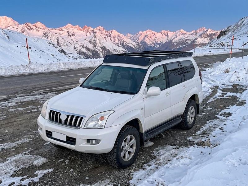 White Land Cruiser Prado 120 with the low-profile roof rack in the snow