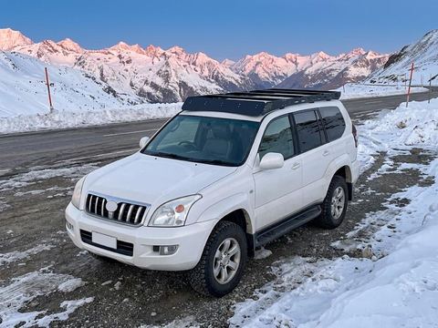 White Land Cruiser Prado 120 with the low-profile roof rack in the snow
