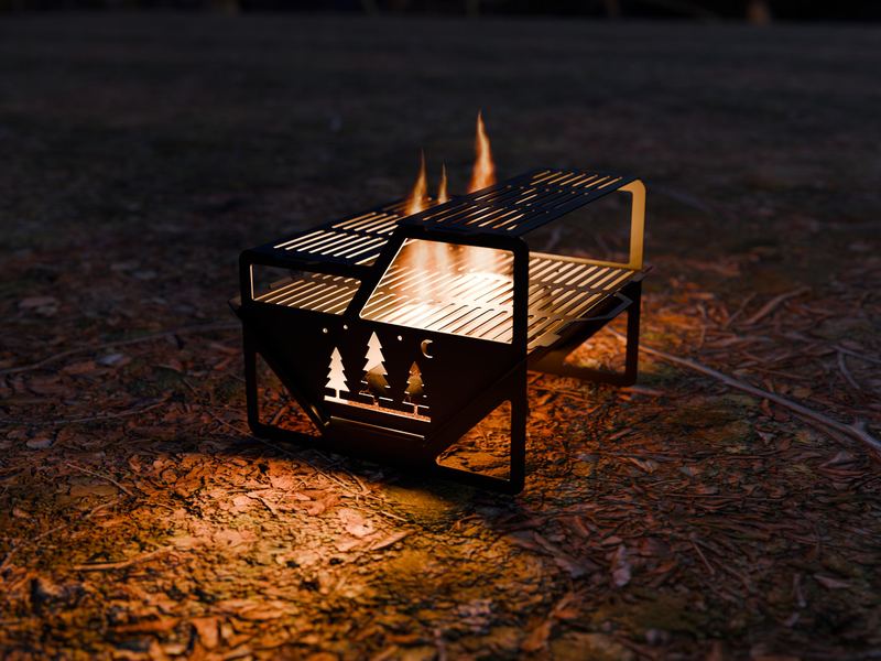 Portable steel fire pit with grill grates and a glowing pine tree end panel at night